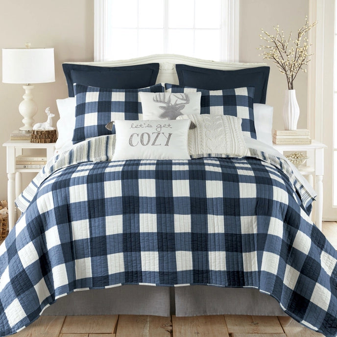Bed with blue and white checkered bedding in a bedroom setting.