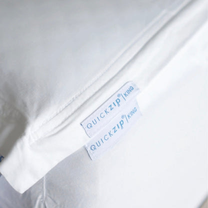 Close-up of a white bedding item, a  Quickzip Fitted Sheet , with two white labels reading QuickZip King.