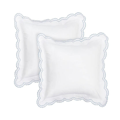 Two white square decorative pillows with scalloped edges, arranged overlapping on a plain white background.